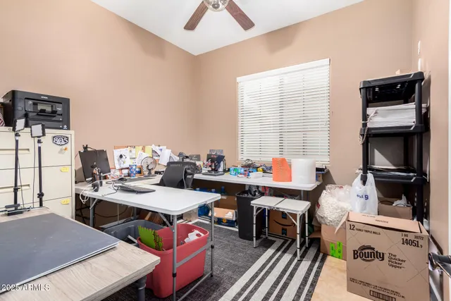 a view of a workspace with furniture and a window
