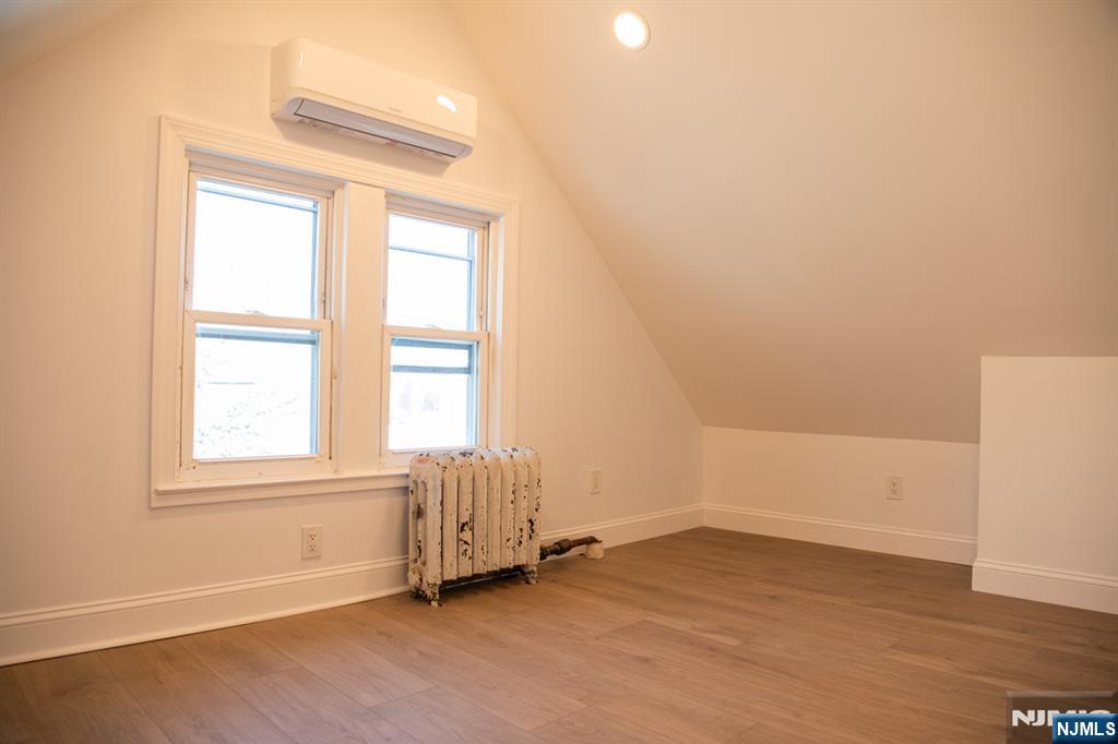 46 Garden Place, Unit 2 Edgewater, NJ 07020 - Photo 14 of 30 an empty room with wooden floor and windows