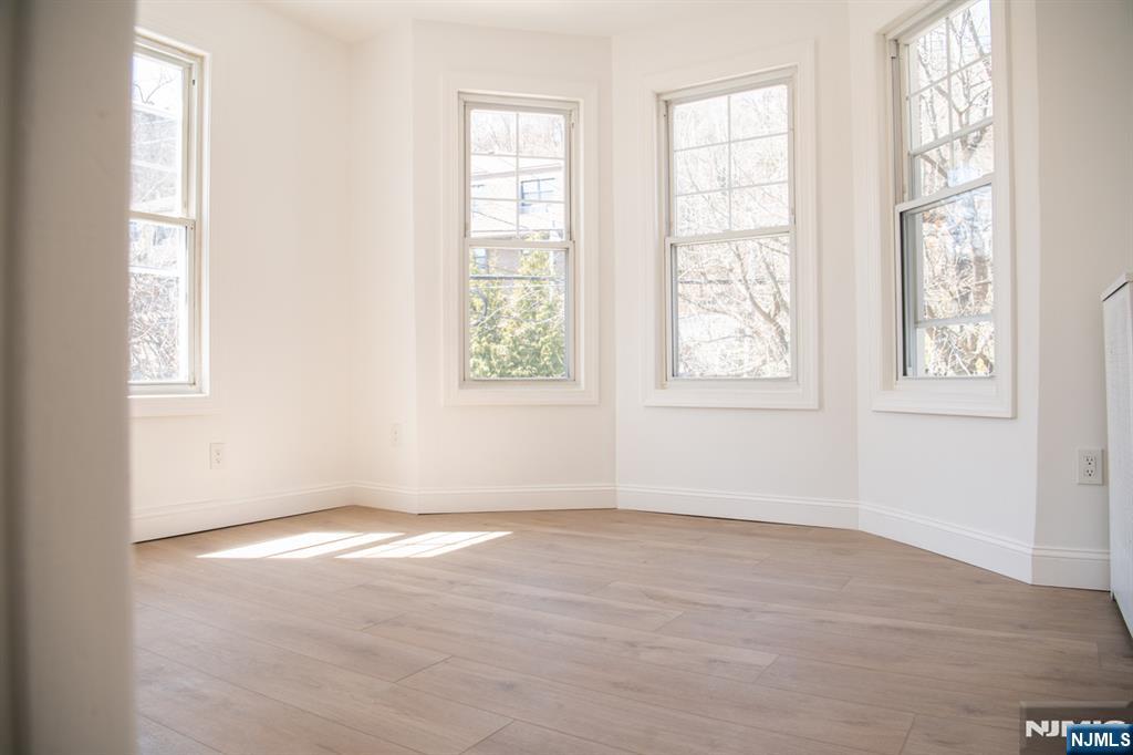 46 Garden Place, Unit 2 Edgewater, NJ 07020 - Photo 6 of 30 an empty room with wooden floor and windows