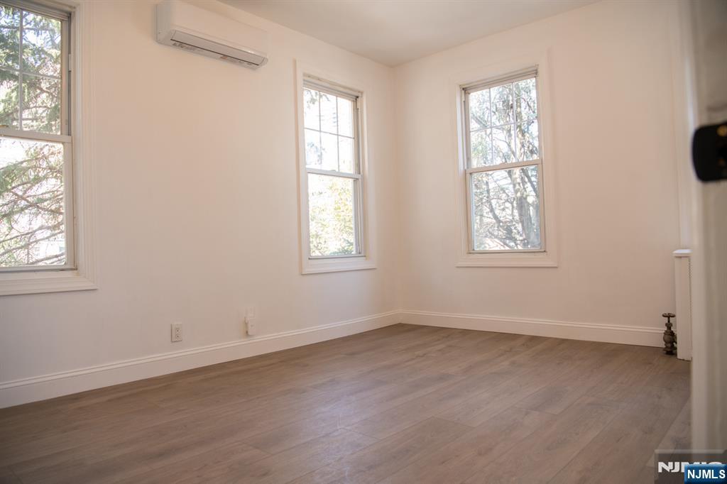 46 Garden Place, Unit 2 Edgewater, NJ 07020 - Photo 7 of 30 an empty room with wooden floor and windows