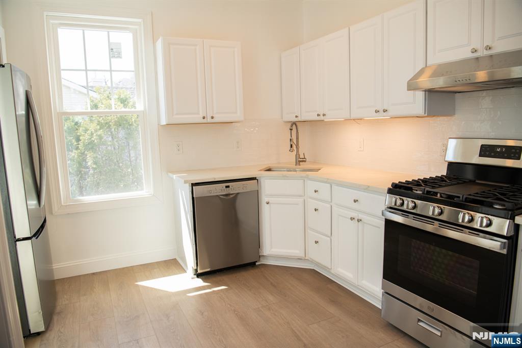 46 Garden Place, Unit 2 Edgewater, NJ 07020 - Photo 9 of 30 a kitchen with white cabinets and appliances