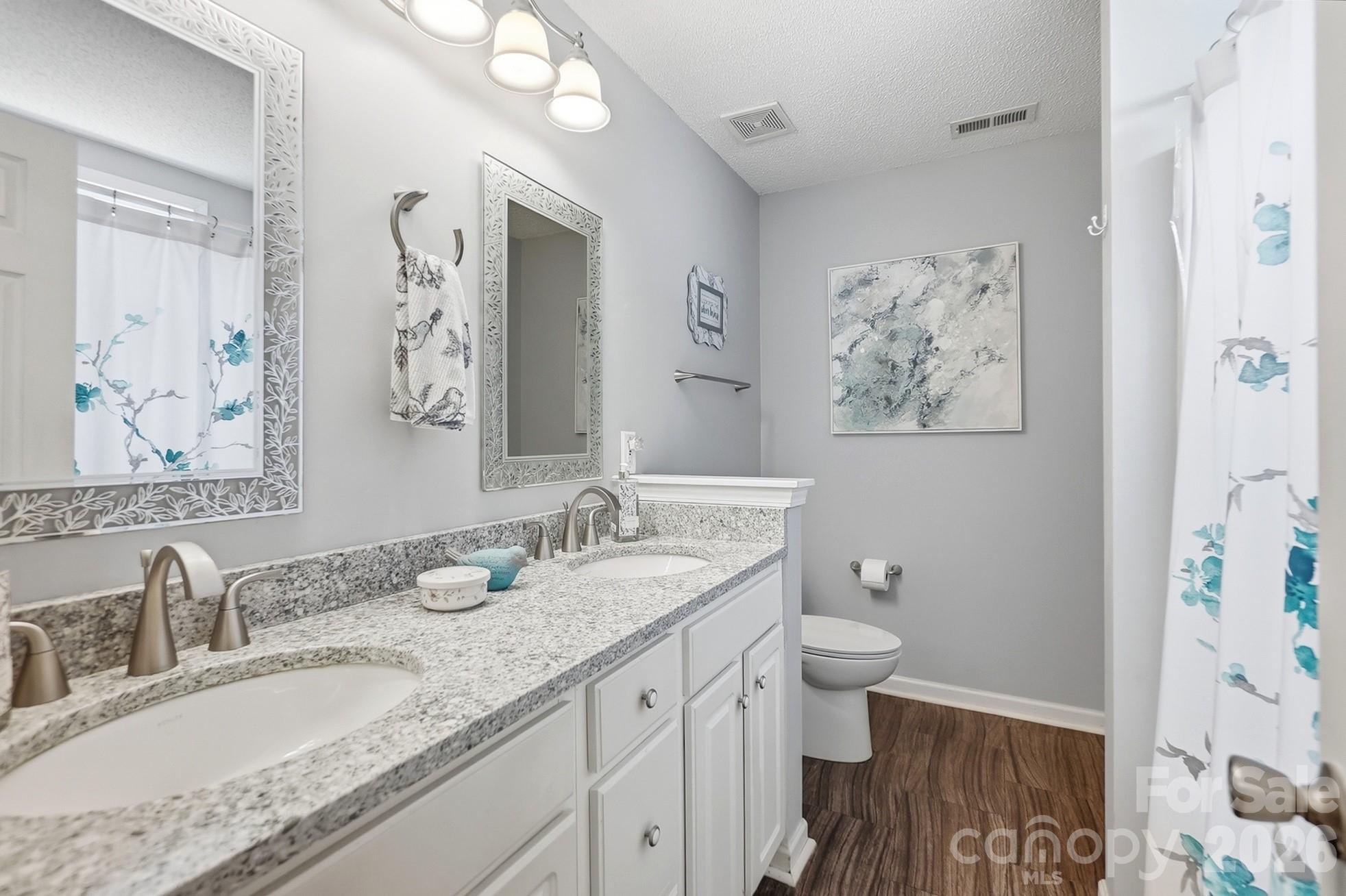 442 Sugar Maple Drive Tega Cay, SC 29708 - Photo 21 of 48 a bathroom with a granite countertop sink toilet and a mirror