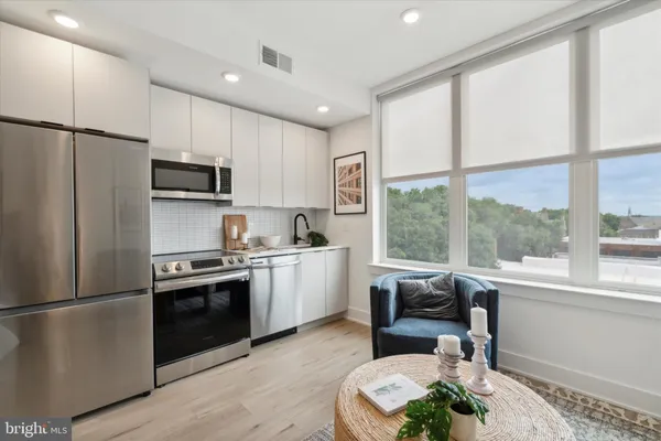 a kitchen with kitchen island granite countertop a stove a sink and a refrigerator