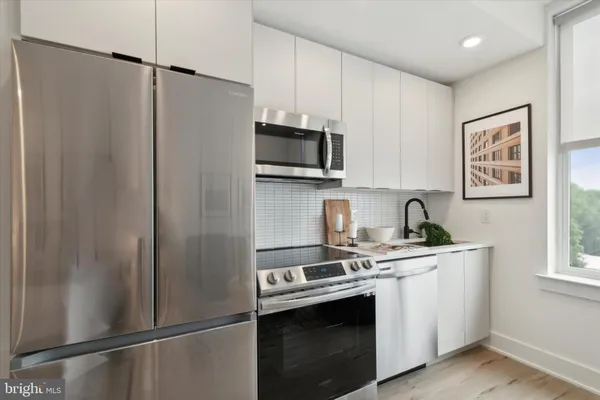 a kitchen with stainless steel appliances white cabinets and a sink
