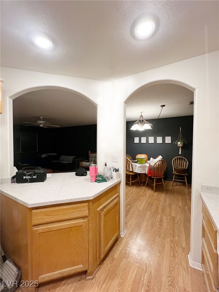 2311 West Mae Road Pahrump, NV 89060 - Photo 6 of 24 Kitchen featuring light brown cabinetry, a textured ceiling, light wood-style flooring, and arched walkways