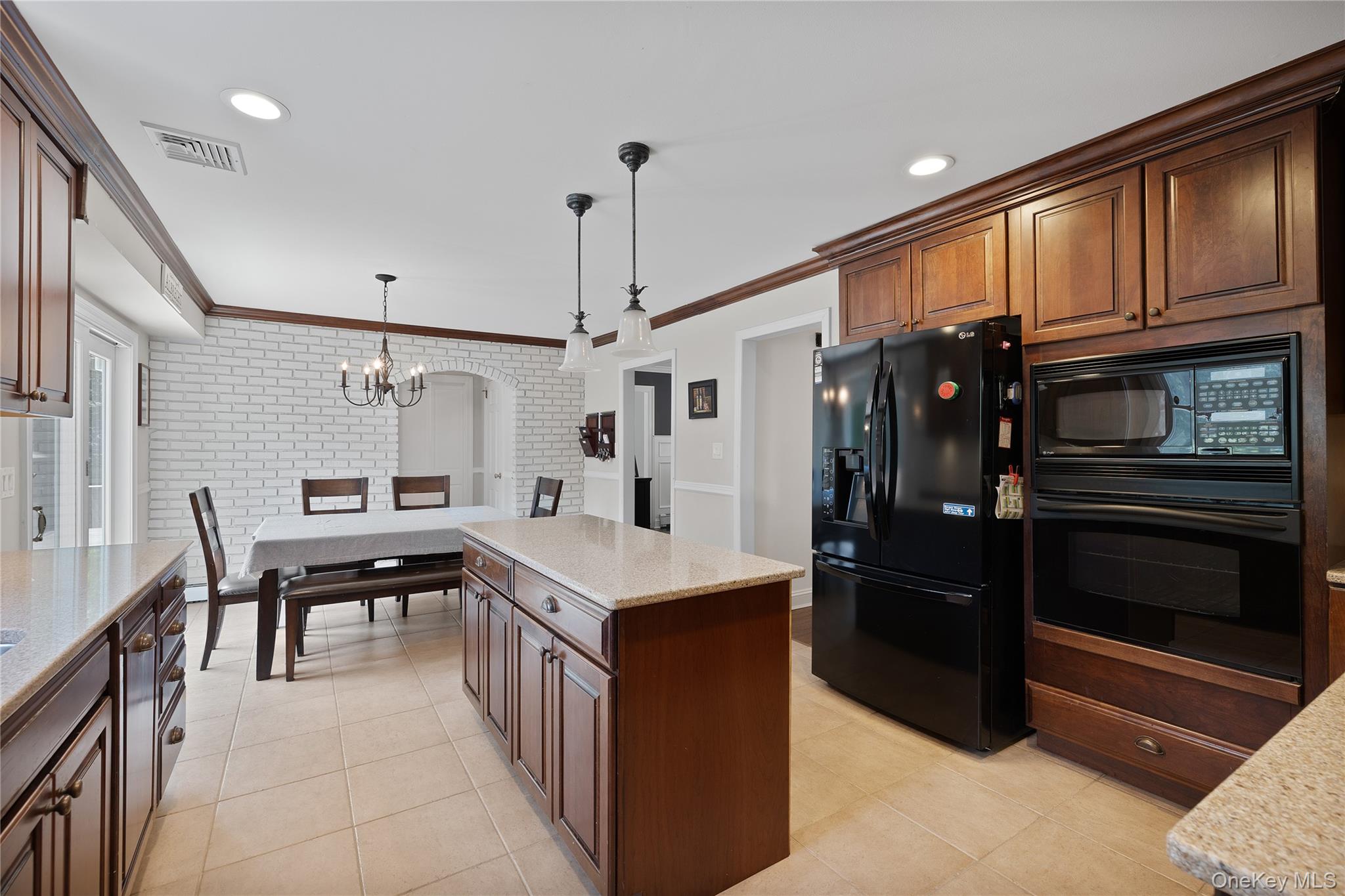 9 Three Sisters Road St. James, NY 11780 - Photo 8 of 36 Kitchen featuring wood cabinetry, light-toned countertops, and tile flooring