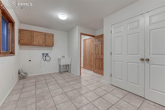 14645 Sterling Road Colorado Springs, CO 80921 - Photo 22 of 49 Main level laundry room with plenty of light, storage and a utility sink