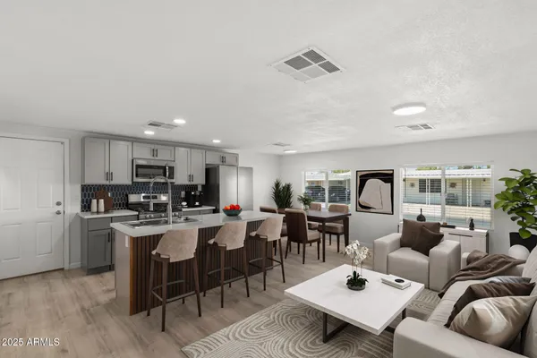 a living room with lots of furniture and kitchen view