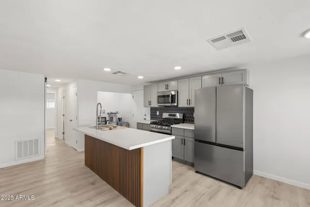 a kitchen with a sink a refrigerator a microwave and cabinets