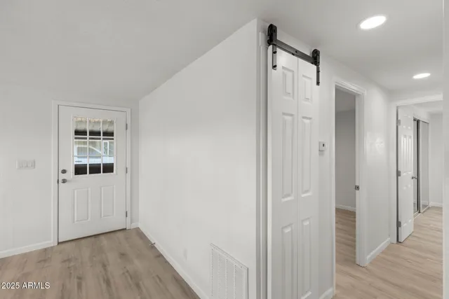 a view of a hallway with wooden floor and closet