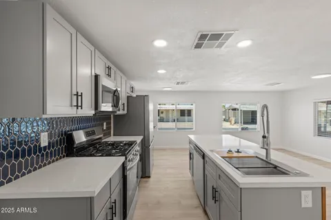 a kitchen with stainless steel appliances granite countertop a stove and a sink