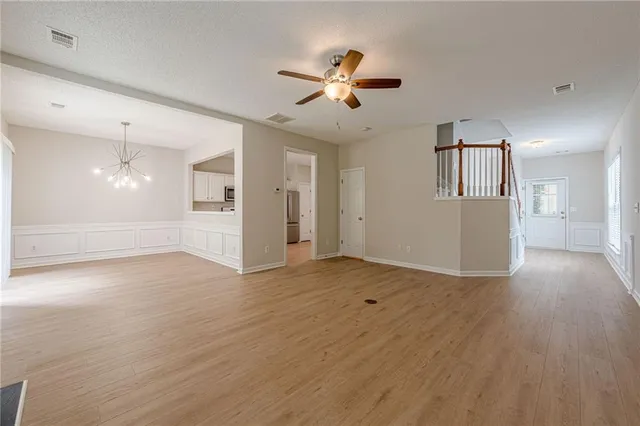 a view of an empty room with wooden floor fireplace and a window