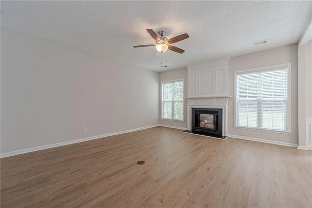 a view of empty room with wooden floor and fireplace