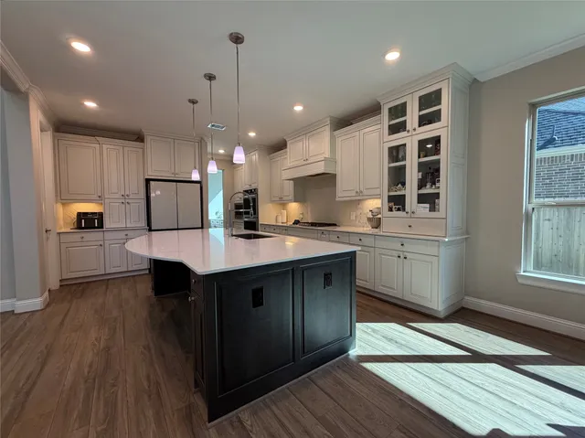 a kitchen with a sink a counter space appliances and cabinets