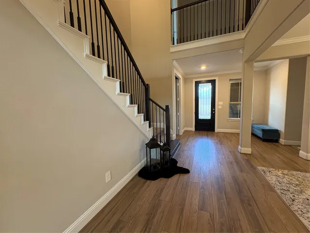 a view of entryway with wooden floor and stairs