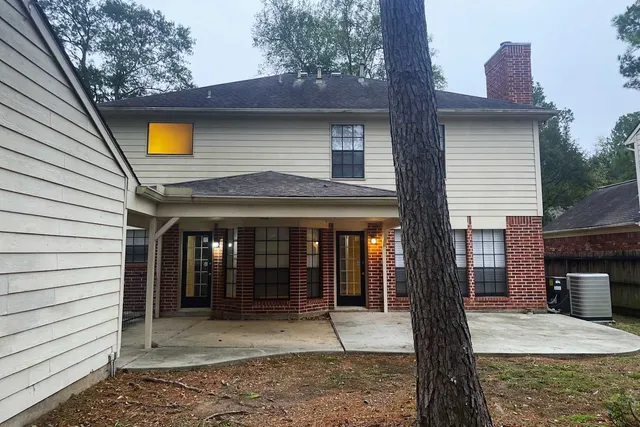 a front view of a house with glass windows and a tree