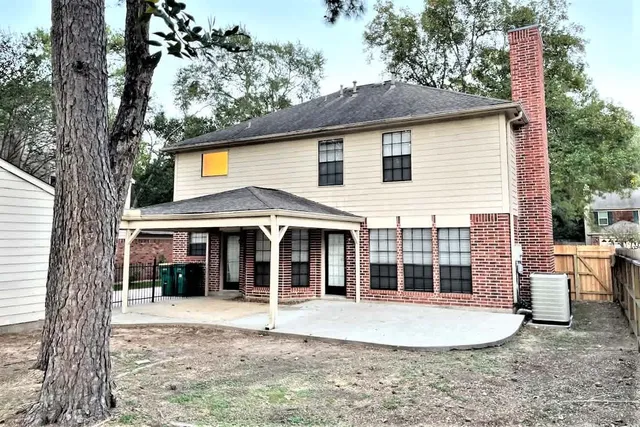 a view of a white house with a large window and large tree