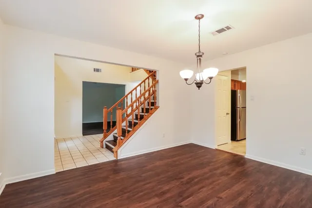 a view of a hallway with wooden floor and staircase