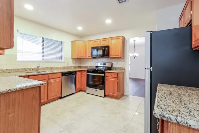 a kitchen with stainless steel appliances granite countertop a stove sink and microwave