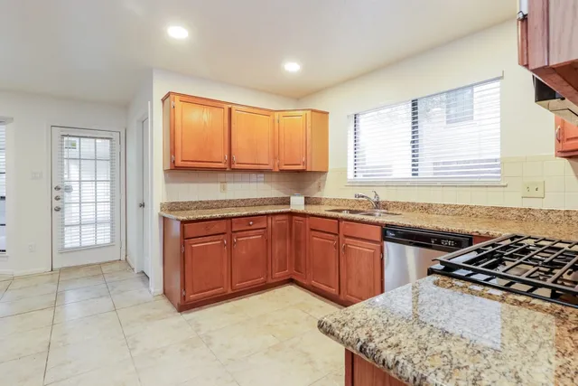 a kitchen with granite countertop a stove sink and cabinets