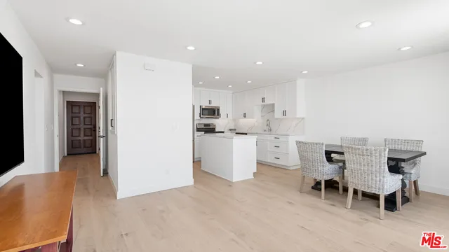 a kitchen with a dining table chairs and refrigerator