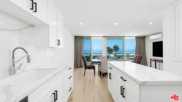 a large white kitchen with a large window
