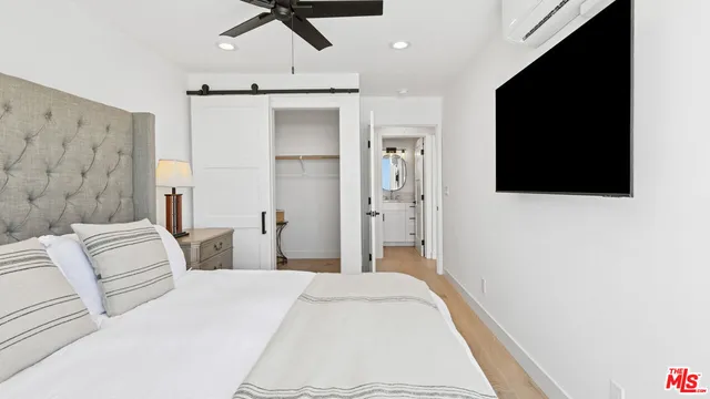a bedroom with a bed and a flat screen tv
