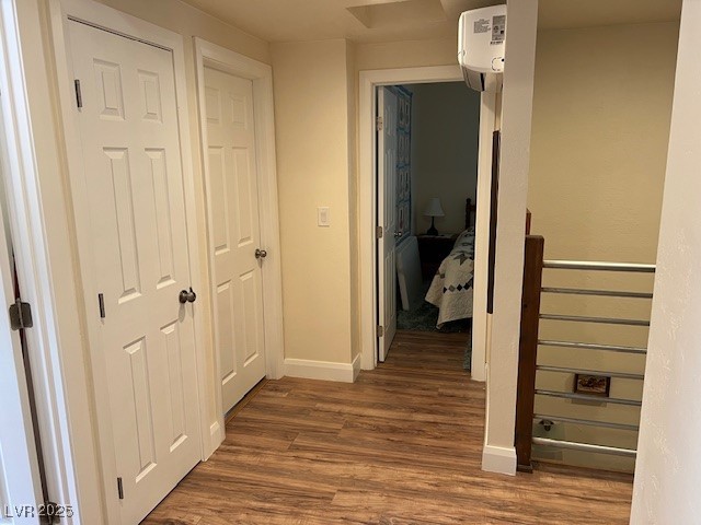 944 Main Street Panaca, NV 89042 - Photo 22 of 24 Hallway with an AC wall unit and dark hardwood / wood-style flooring