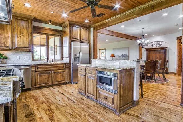 a kitchen with stainless steel appliances granite countertop a stove a sink and a microwave