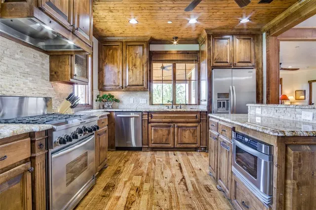 a kitchen with stainless steel appliances granite countertop a stove and a sink