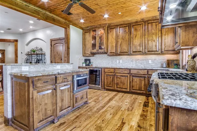 a kitchen with stainless steel appliances granite countertop wooden cabinets a sink and dishwasher