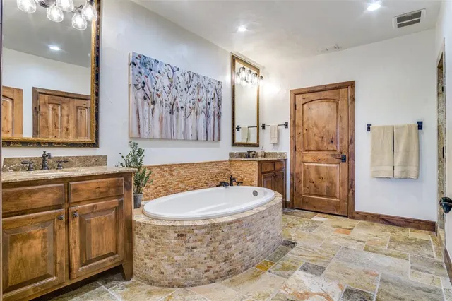 a bathroom with a tub sink and mirror