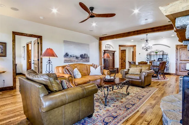 a living room with furniture kitchen view and a chandelier