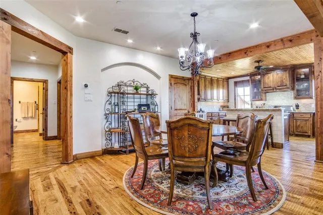 a view of a a dining room with furniture a chandelier and wooden floor