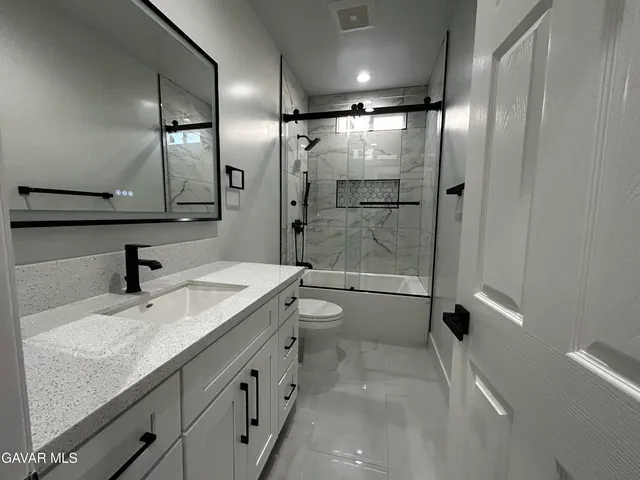 a bathroom with a double vanity sink toilet and shower