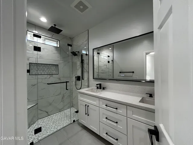 a bathroom with a shower sink and mirror