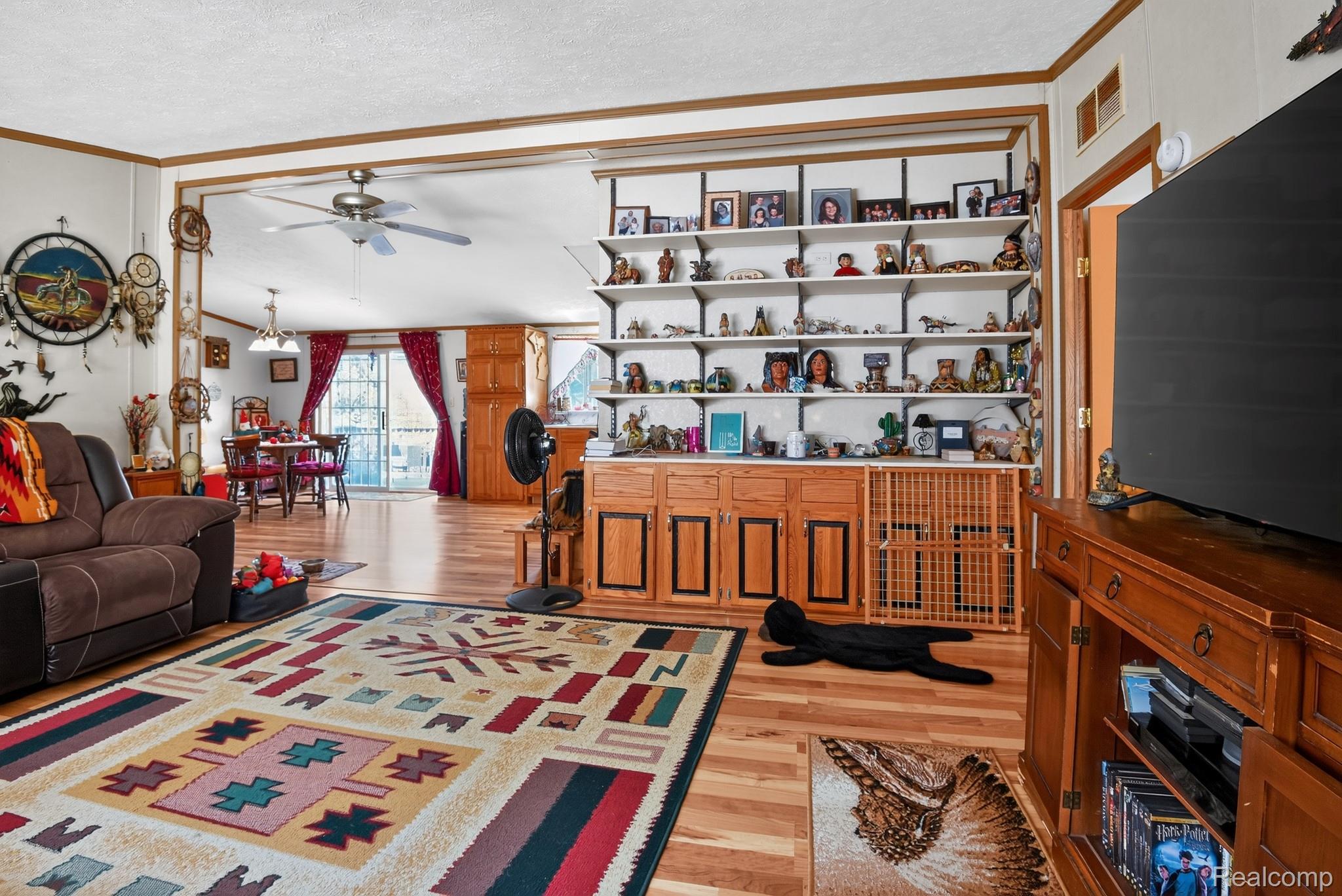 6266 Kikendall Road Eaton Rapids, MI 48827 - Photo 12 of 36 Wood-finish flooring throughout, built-in shelving, and a ceiling fan in the living area
