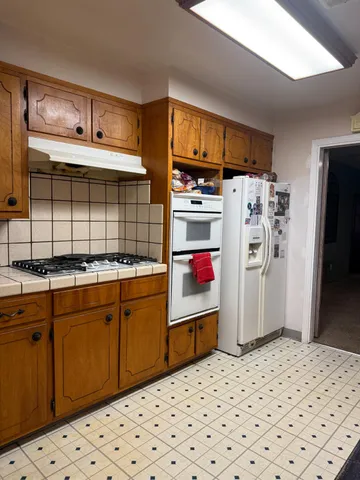 a kitchen with stainless steel appliances kitchen island granite countertop a refrigerator and a stove top oven