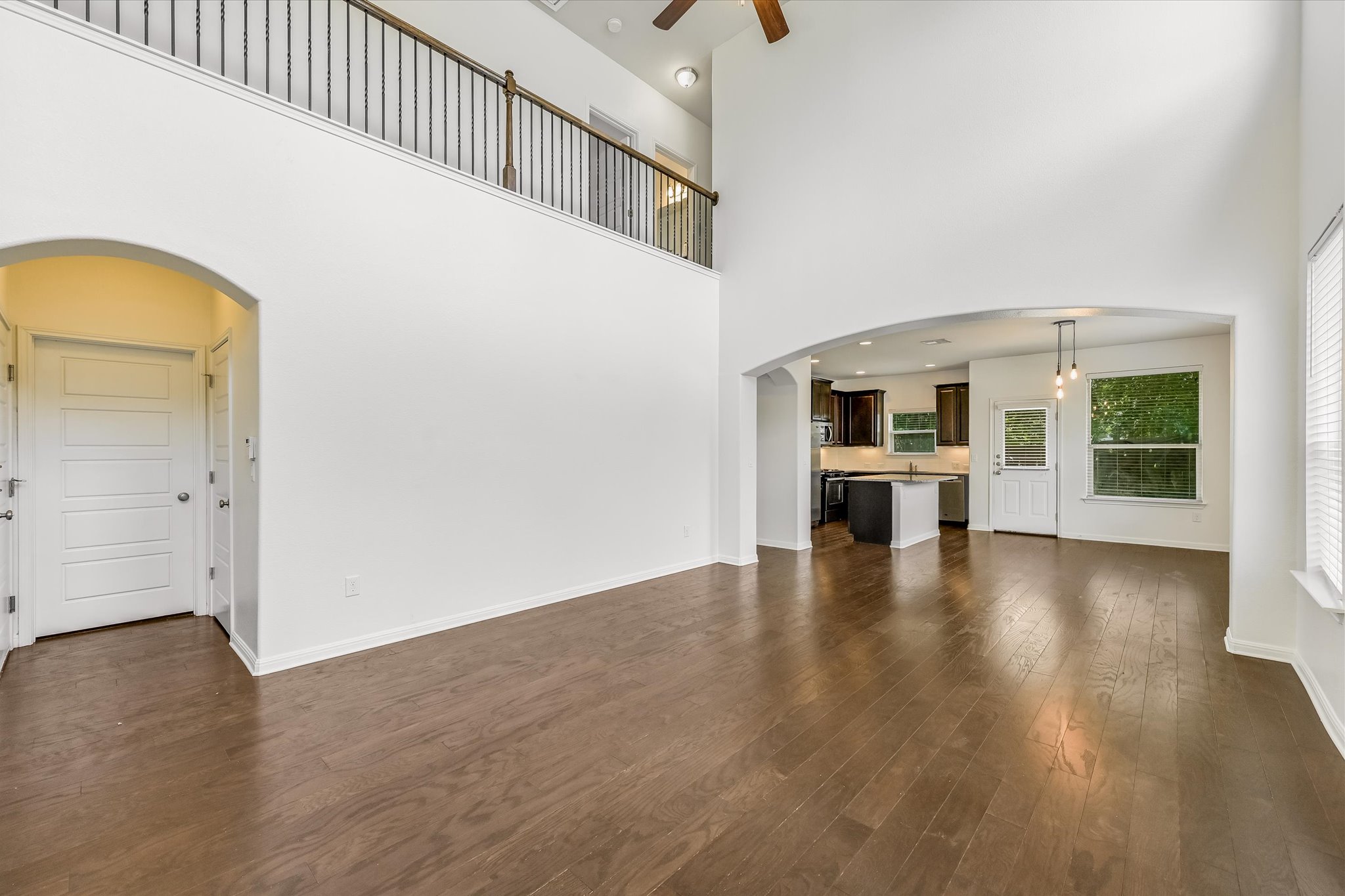 7709 Menchaca Road, Unit 1 Austin, TX 78745 - Photo 7 of 29 Soaring two story living room expands the already spacious room and a wall of windows floods the space with natural light. Convenient powder room for guests located off living room.
