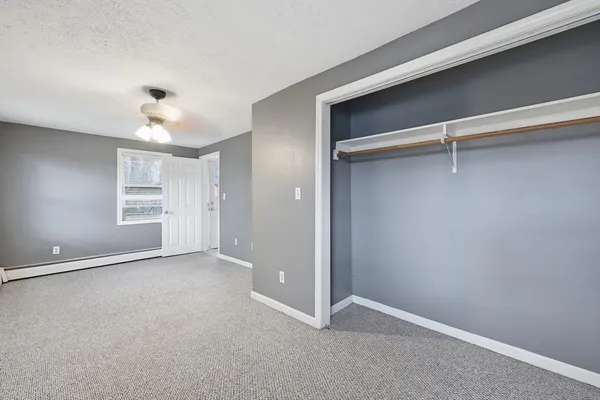 a large white kitchen with granite countertop a sink white cabinets and a stove