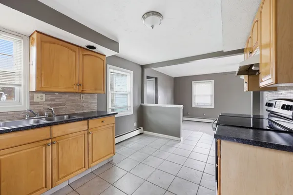 a kitchen with a sink a stove and cabinets