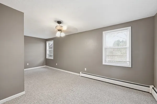 a view of an empty room with a chandelier fan