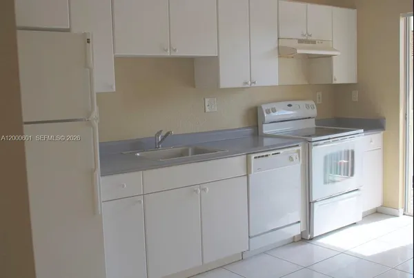 a kitchen with white cabinets and white appliances