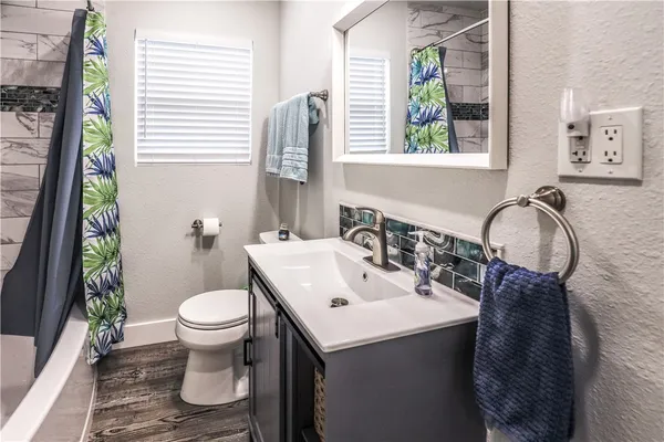 a bathroom with a sink toilet and mirror