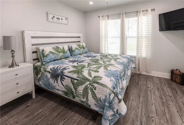 a bedroom with a bed and wooden floor