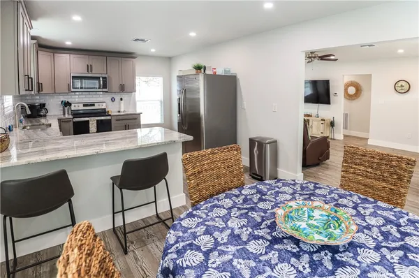 a kitchen with stainless steel appliances kitchen island granite countertop a refrigerator and a stove top oven