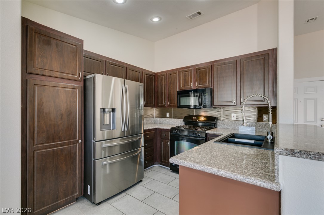 2028 Rustler Ridge Avenue North Las Vegas, NV 89031 - Photo 22 of 40 A well-appointed kitchen showcasing elegant cabinetry and a complete suite of modern appliances.