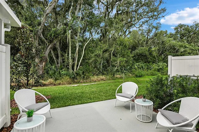 a view of a chair and table in backyard of the house