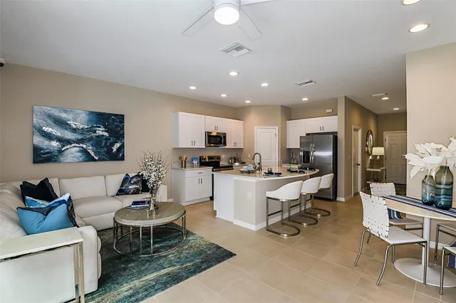 a living room with furniture a kitchen view and a appliances