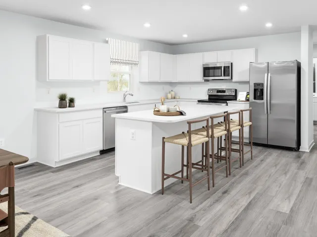a kitchen with a sink a counter top space stainless steel appliances and cabinets